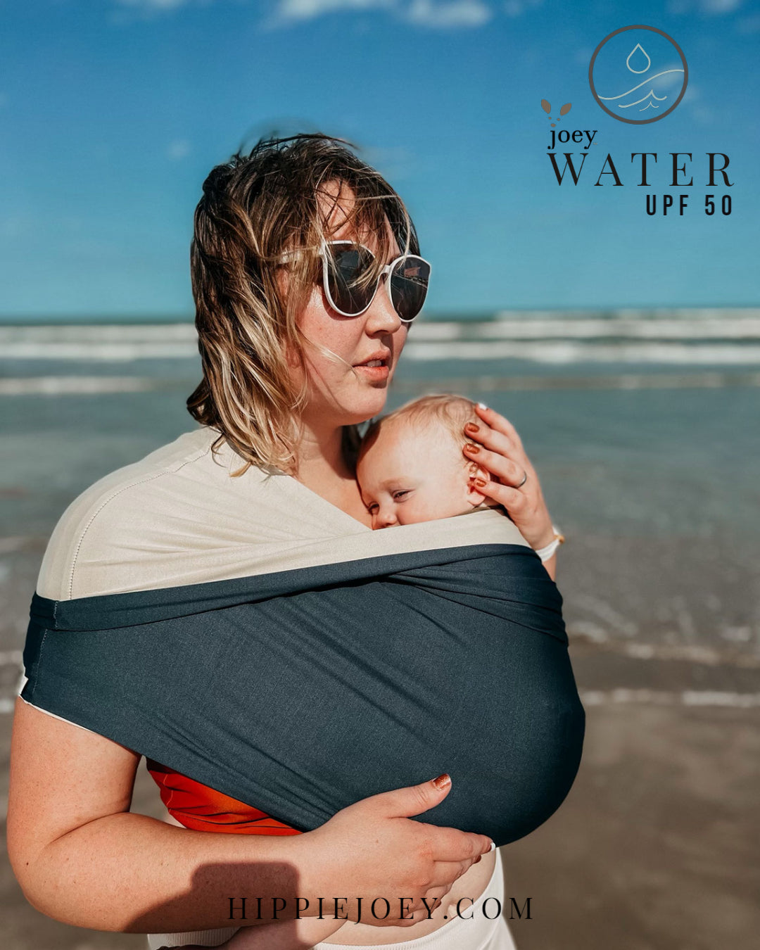 Joey Water ( A waterproof stretchy Sling/ Wrap/ baby carrier type assistant garment)  being used on the beach to keep baby happy