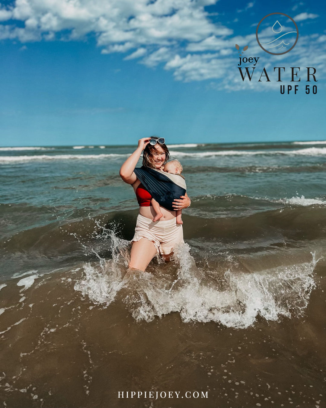 Joey Water ( A waterproof stretchy Sling/ Wrap/ baby carrier type assistant garment)  being used by a mom smiling in the ocean